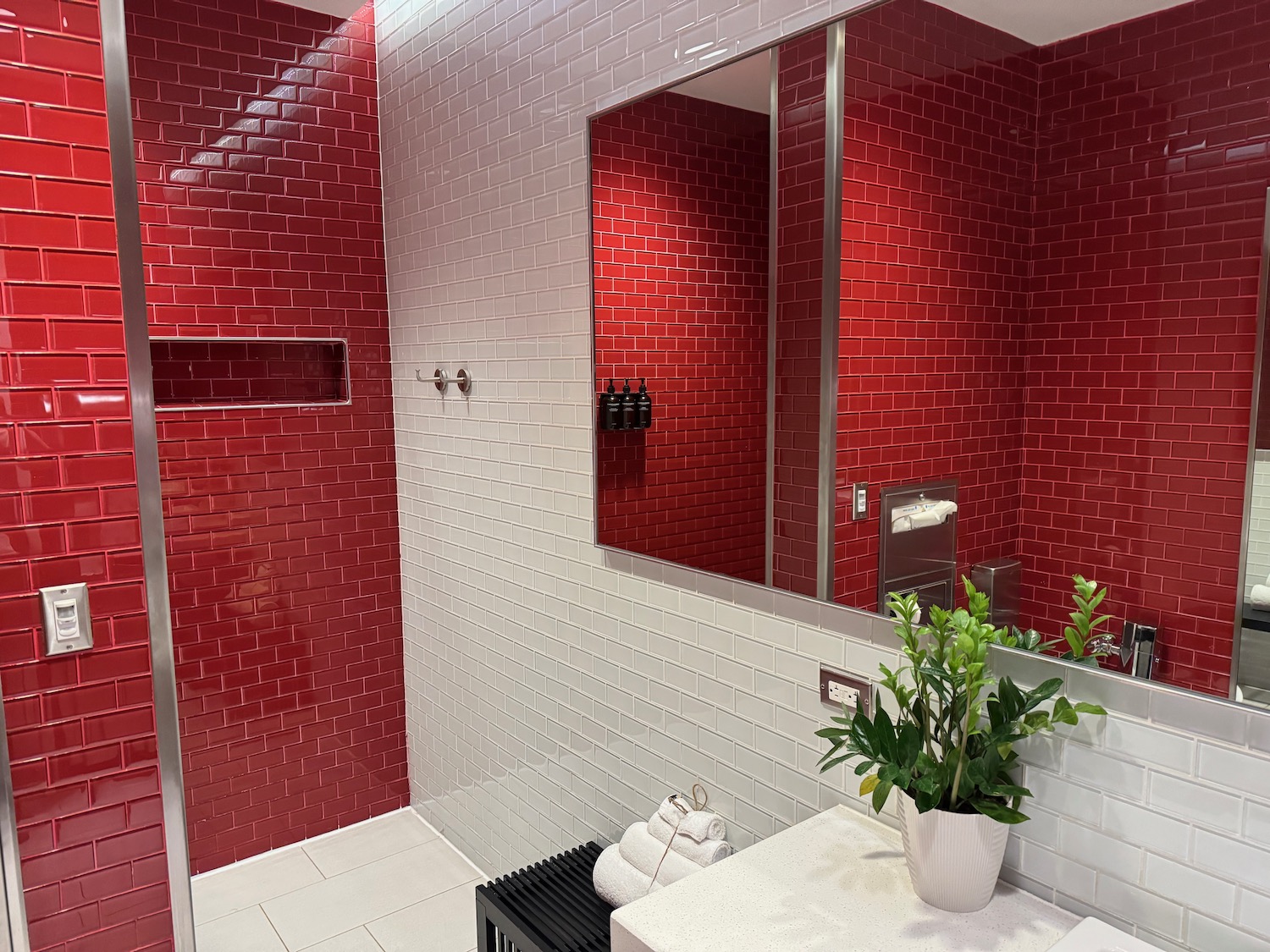 a bathroom with red and white tile walls