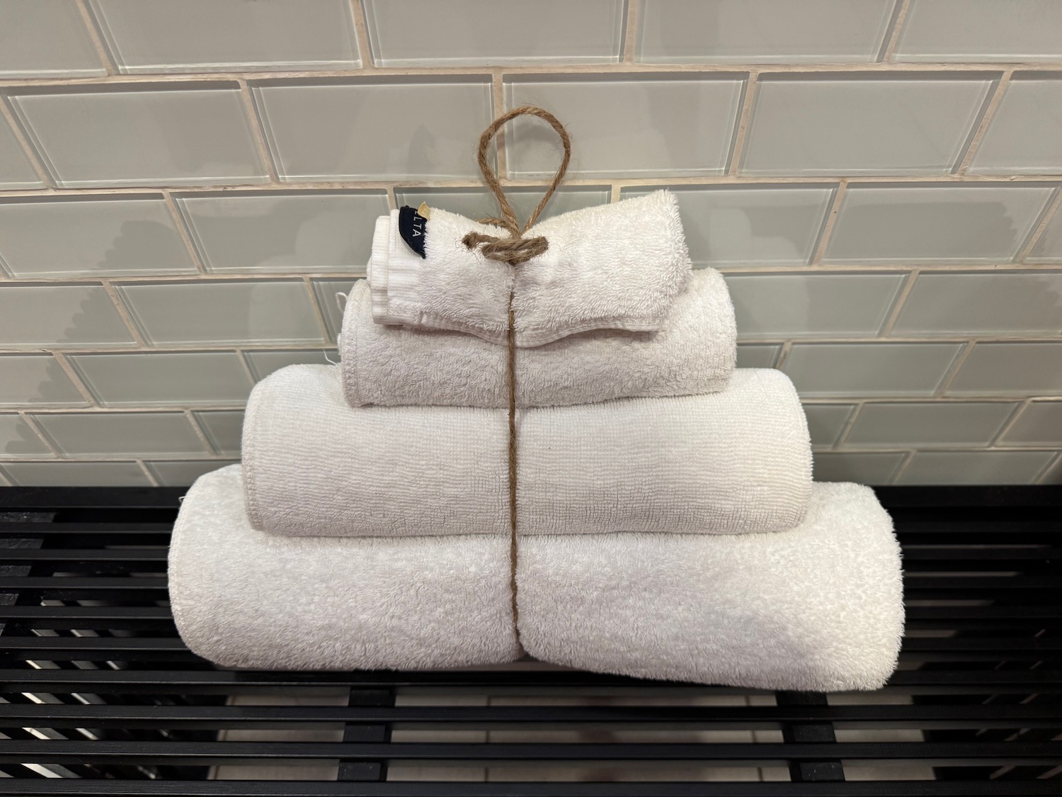 a stack of white towels on a black grate