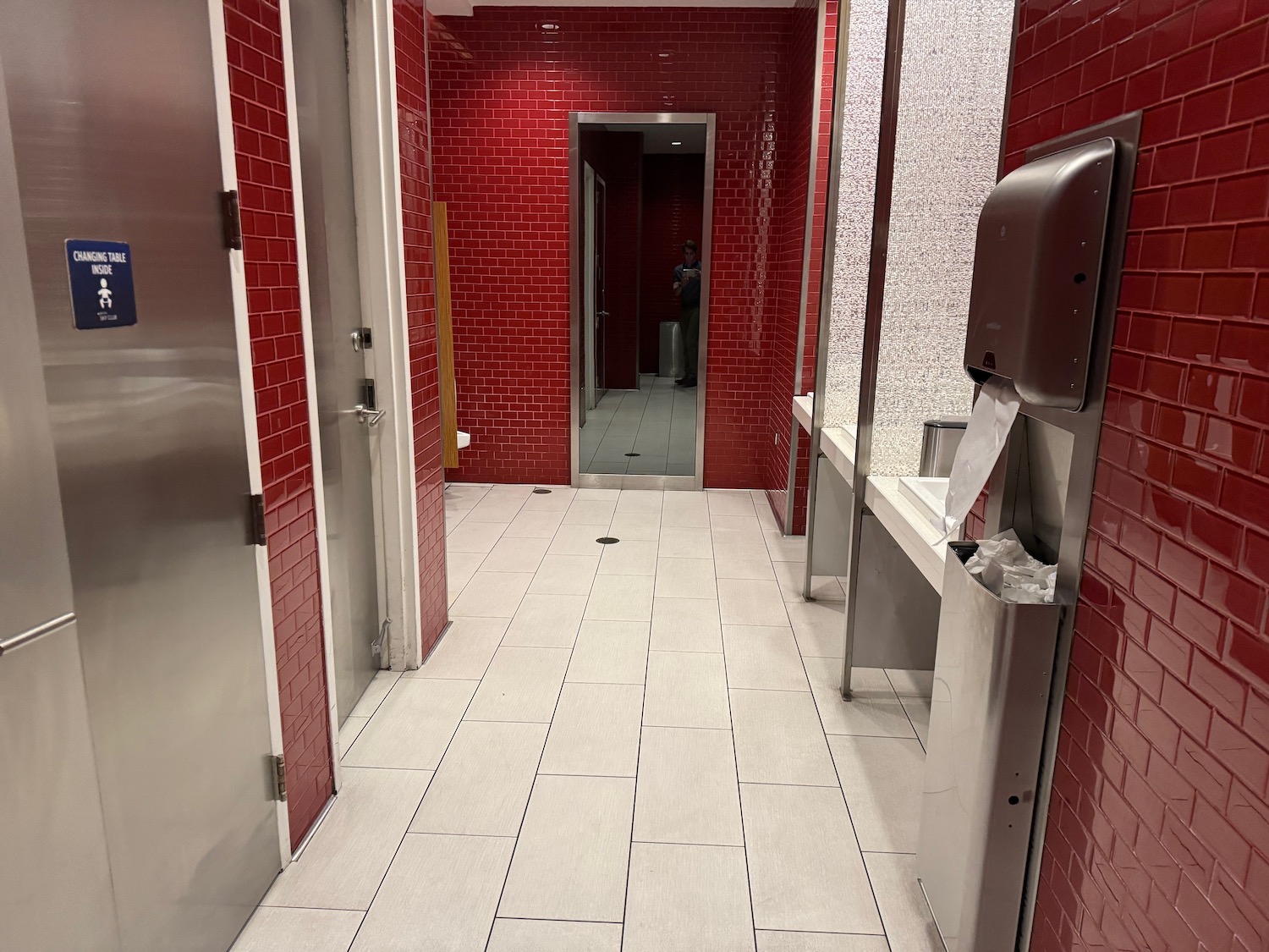 a red tiled bathroom with a mirror