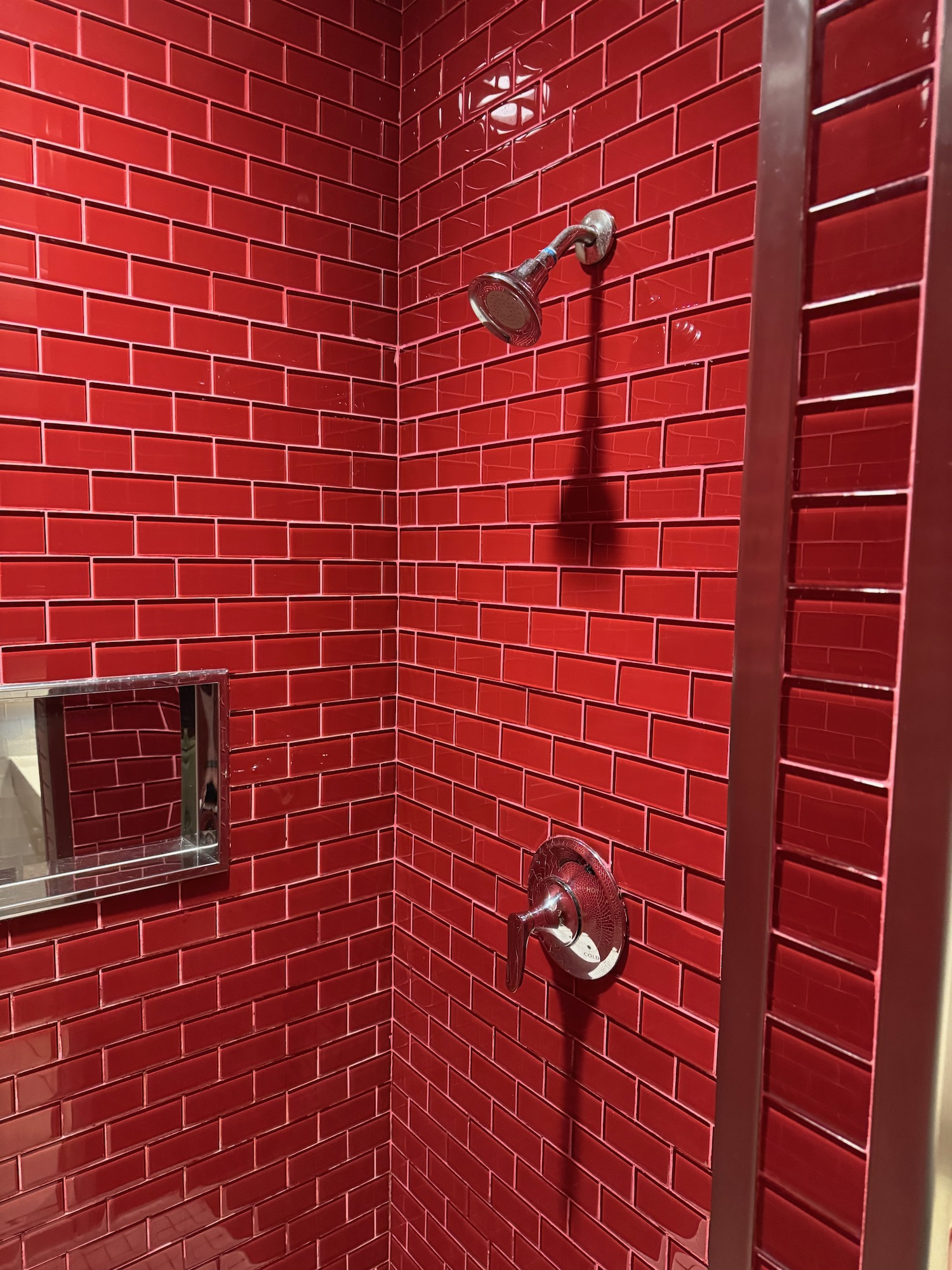 a shower with red tiles