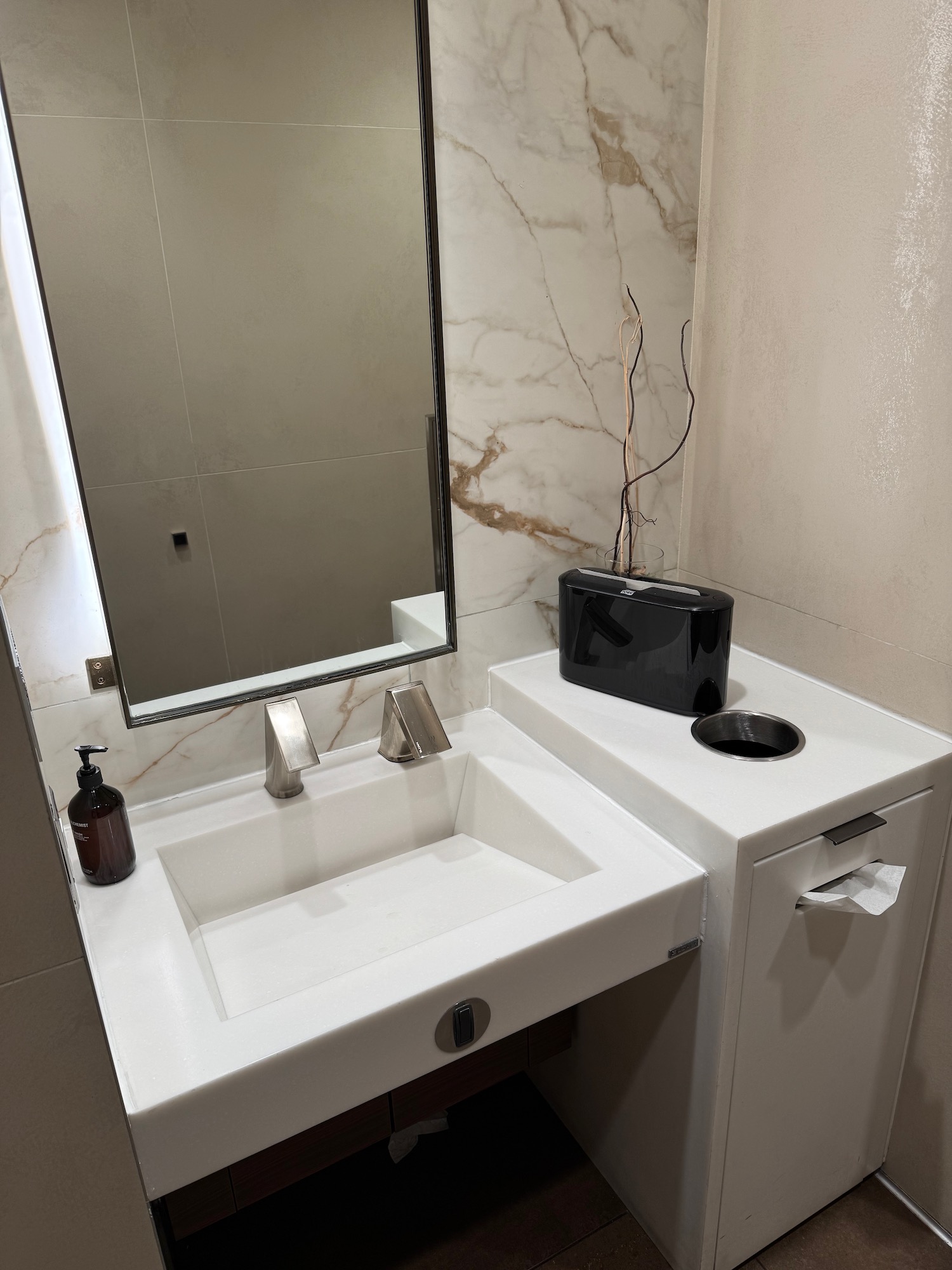 a bathroom sink with a mirror and a black object