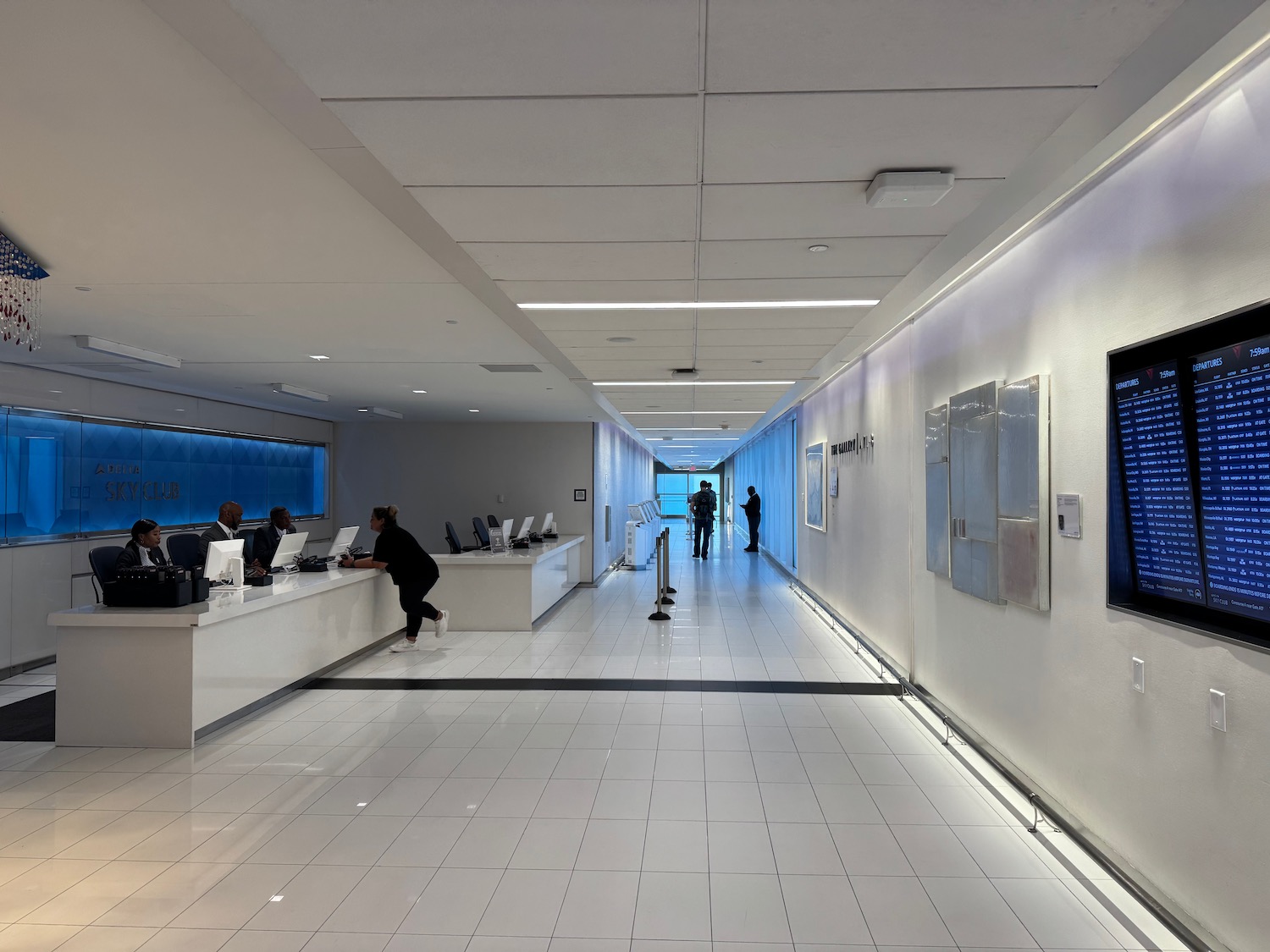a white hallway with people in front of computers