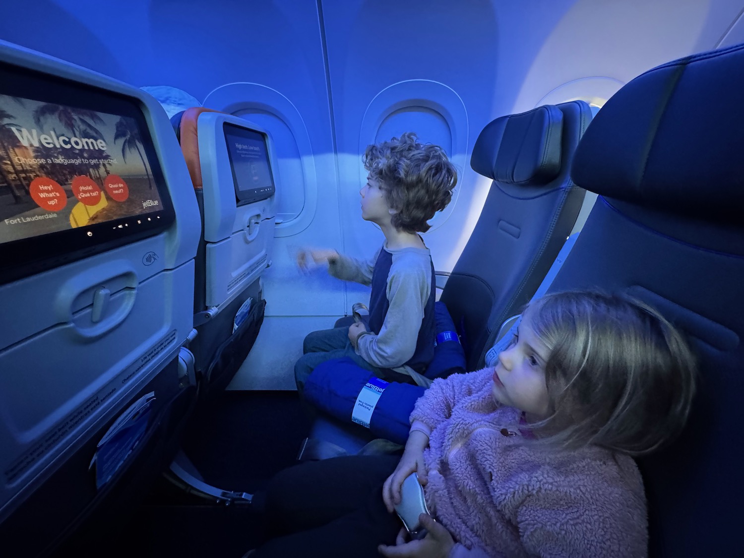 a boy and girl sitting in an airplane