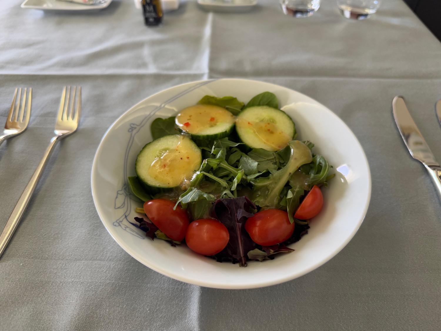 a plate of salad with cucumbers and tomatoes