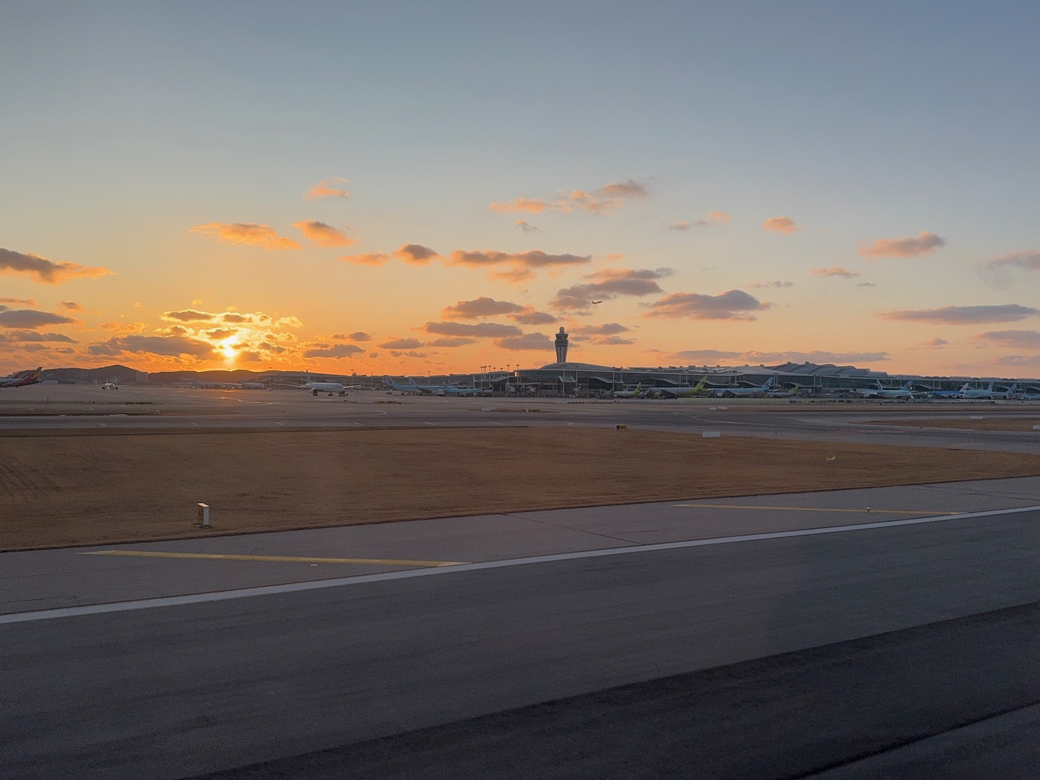 an airport with a sunset in the background
