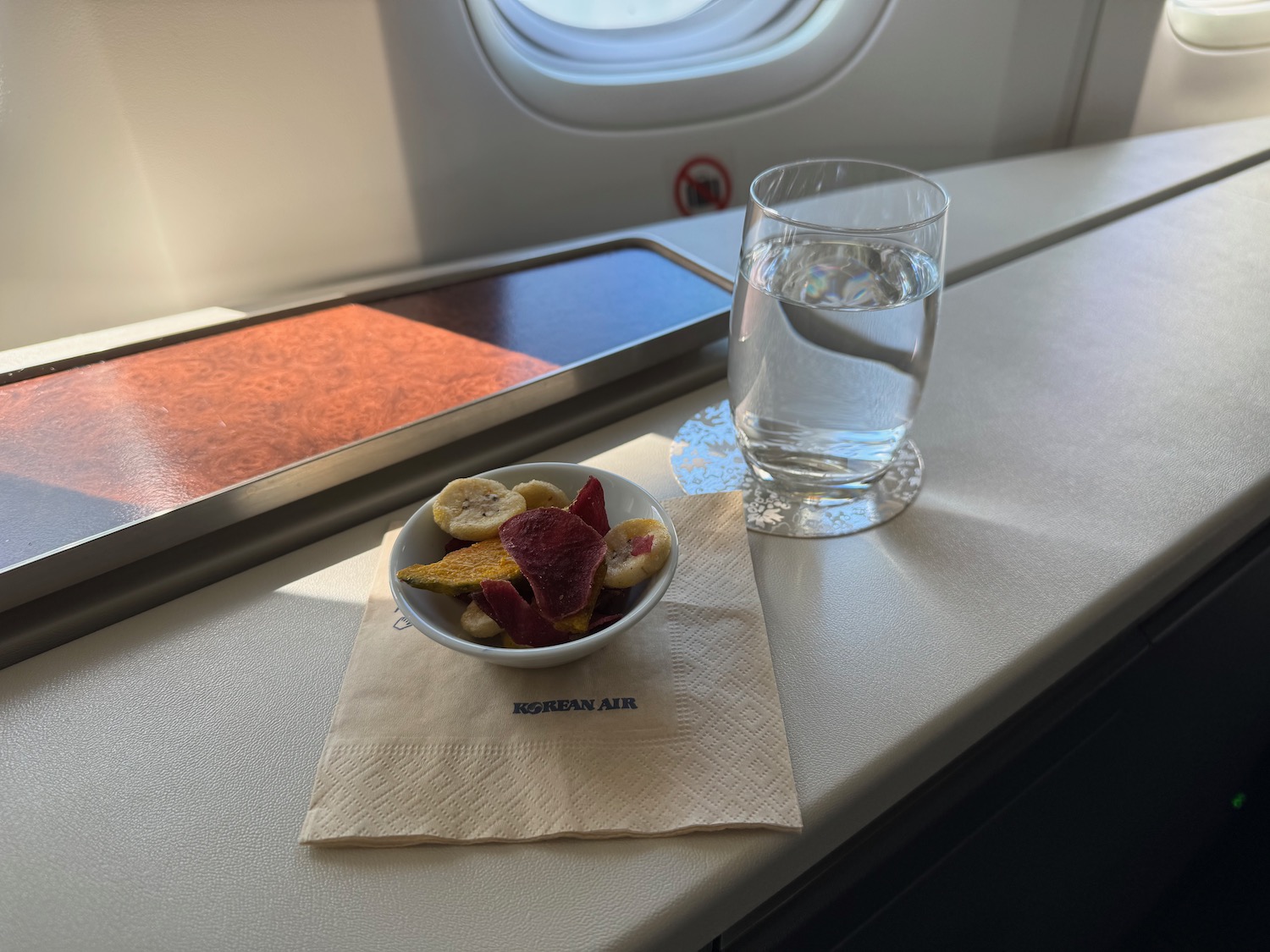 a bowl of fruit and a glass of water on a table