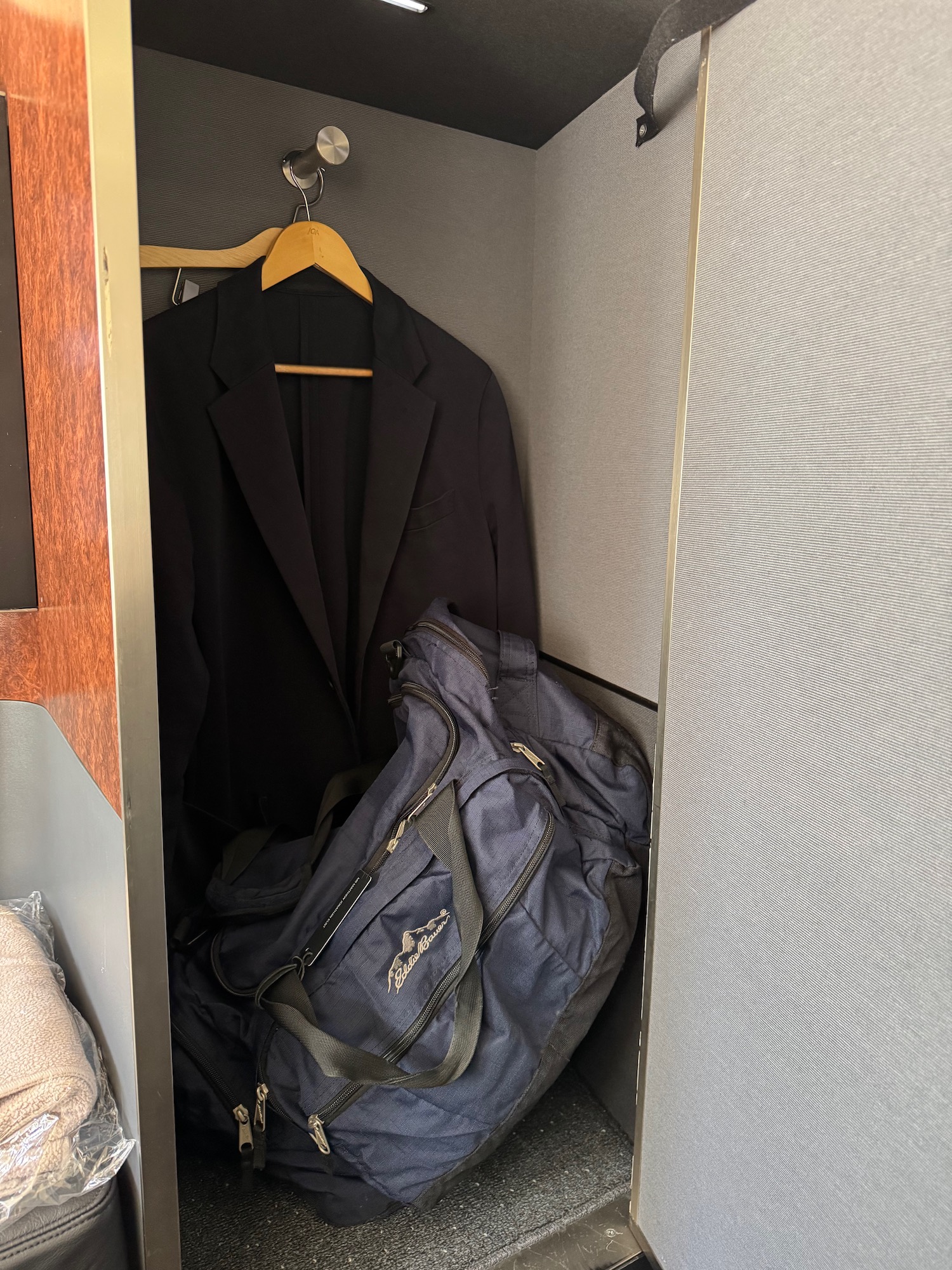 a coat and bag in a closet