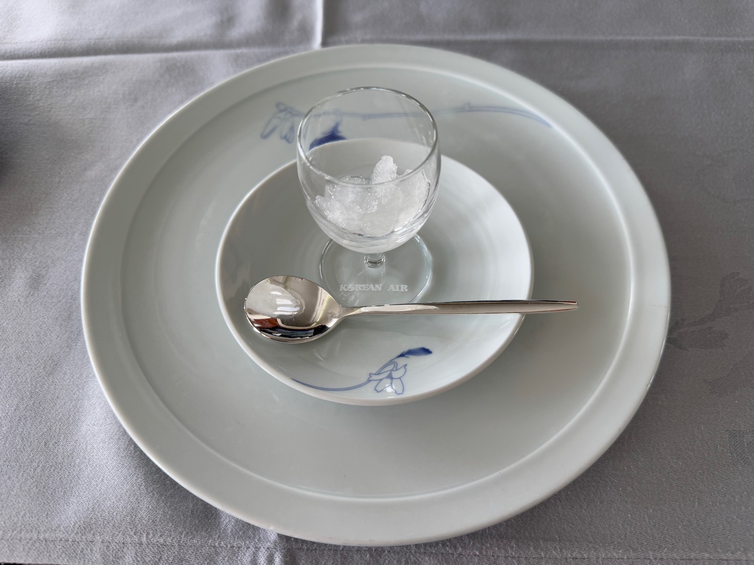 a plate with a spoon and a glass on it