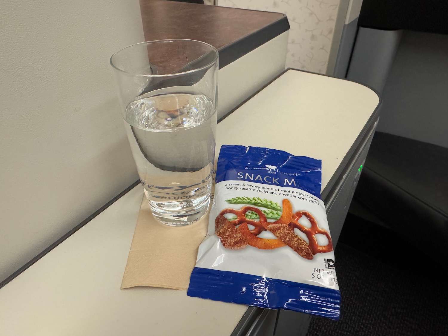 a glass of water and a bag of snacks on a table