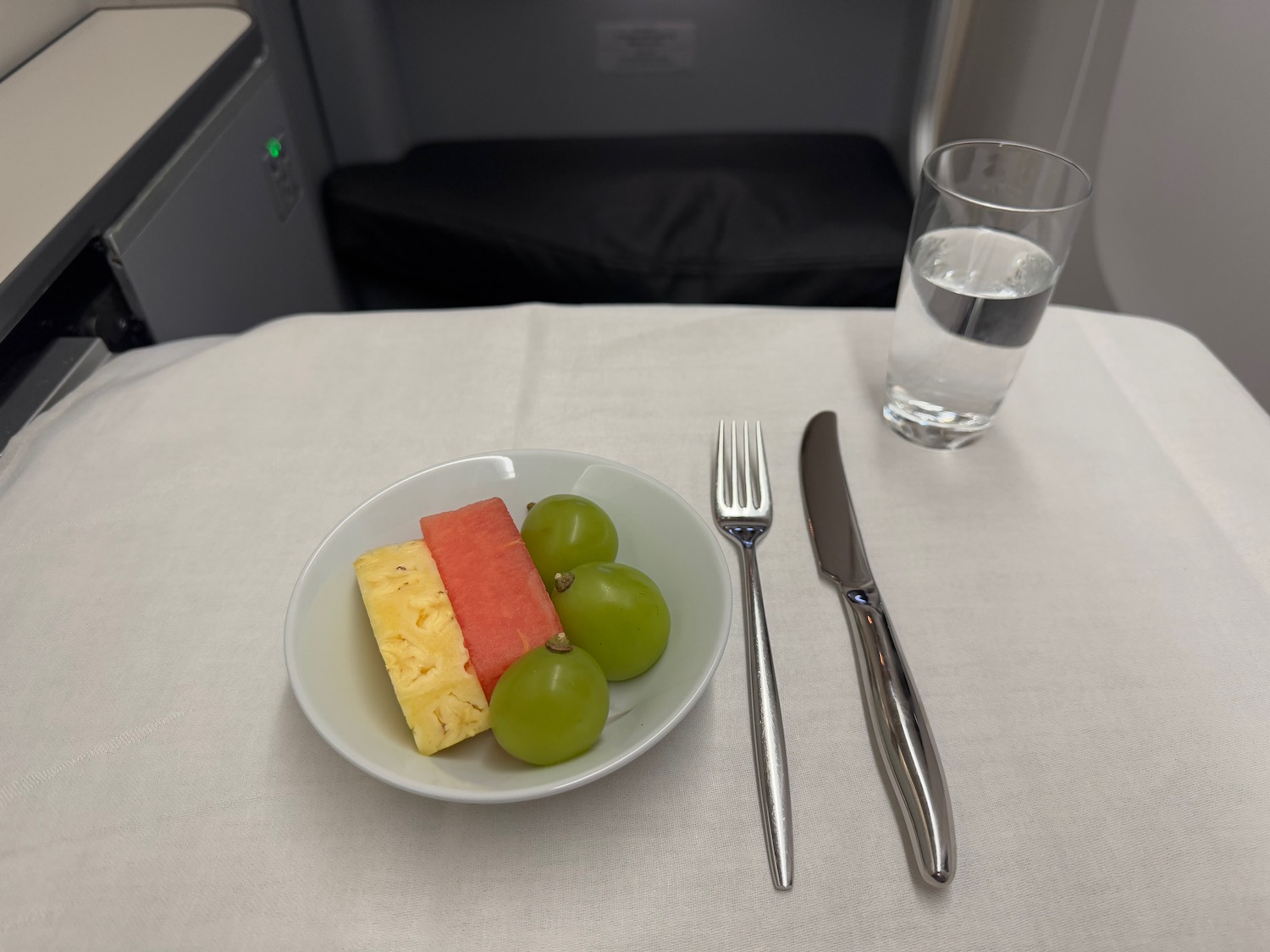 a plate of fruit and a glass of water on a table