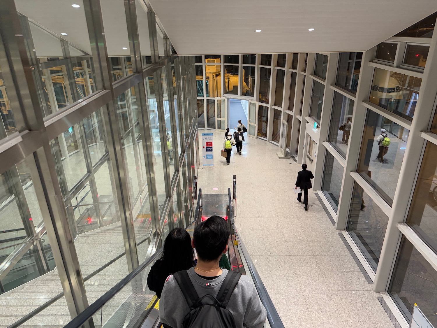 people walking down a walkway with people walking down the stairs