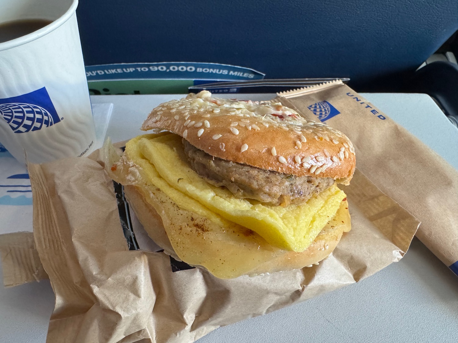 a burger with egg and cheese on a paper bag