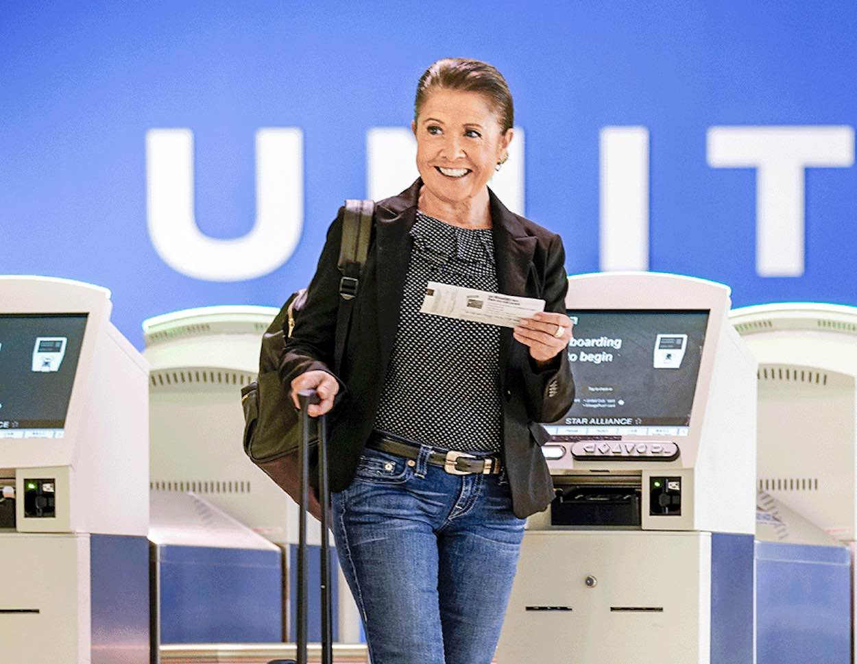 a woman holding a piece of paper and luggage