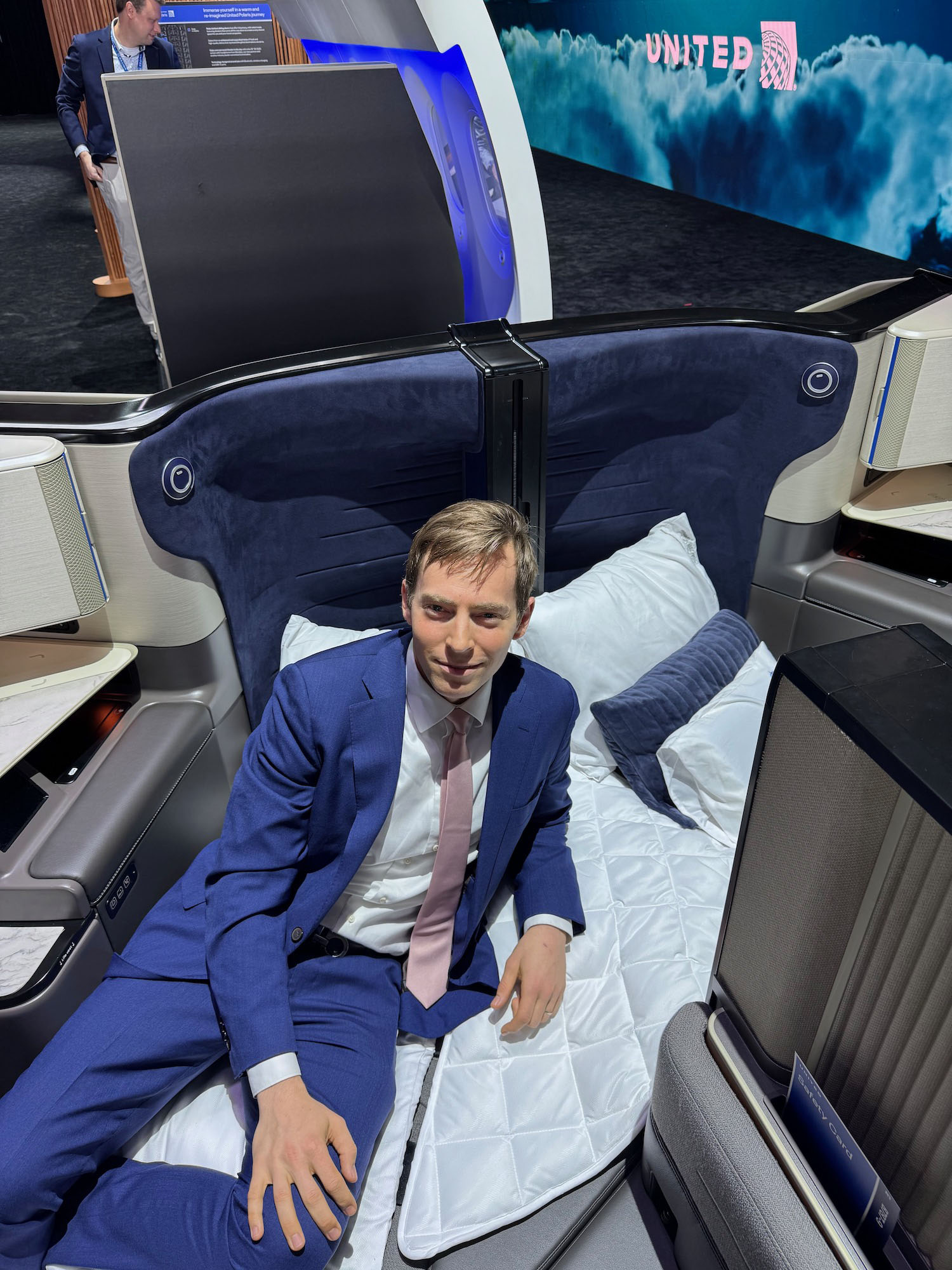 a man in a suit sitting on a bed