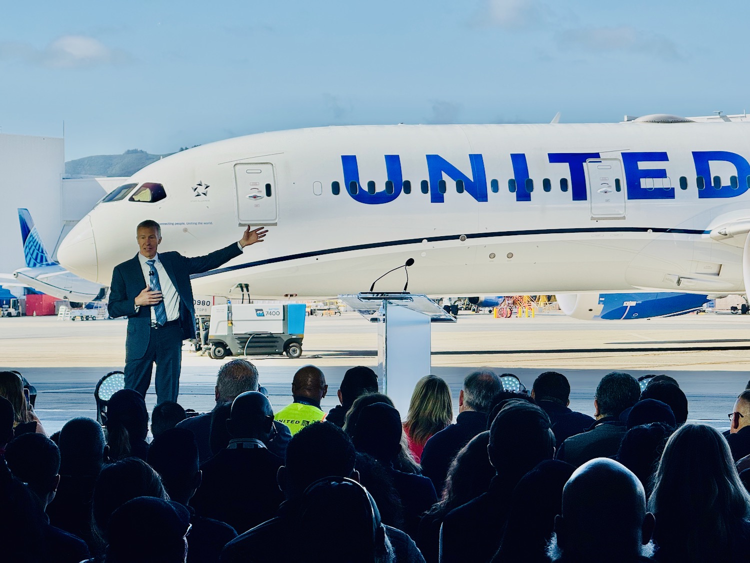a man standing in front of a large white airplane