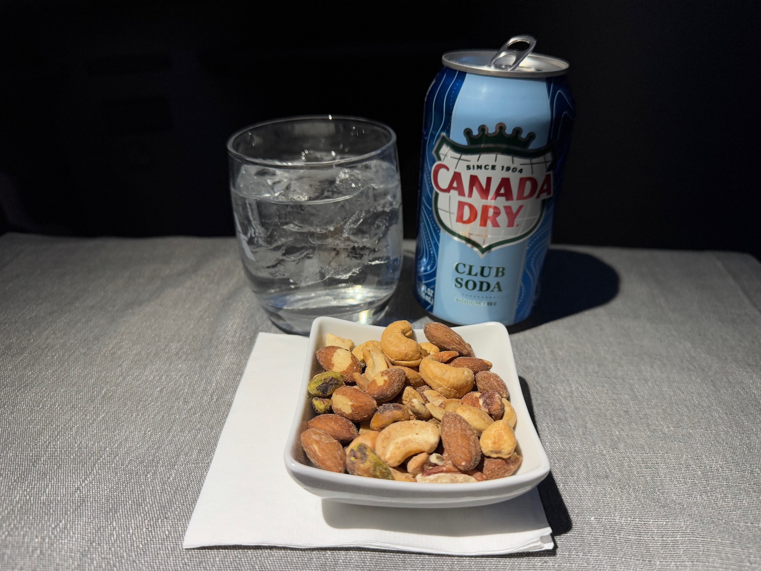 a bowl of nuts and a can of soda