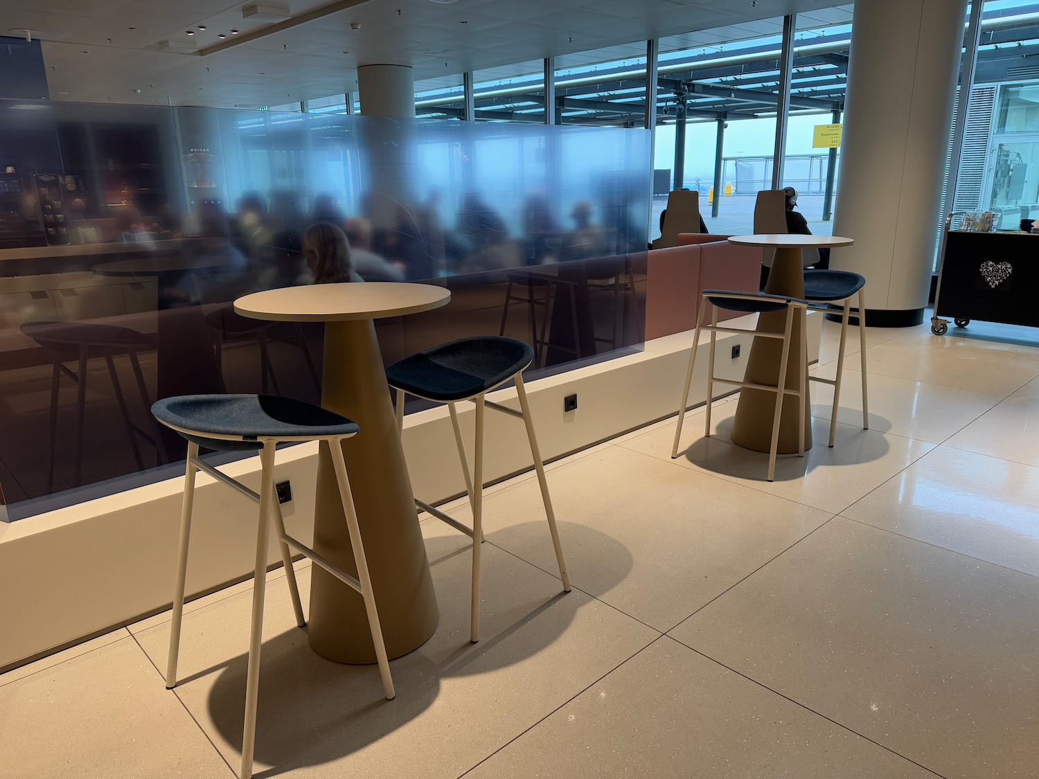 a group of people sitting in a room with tables and chairs