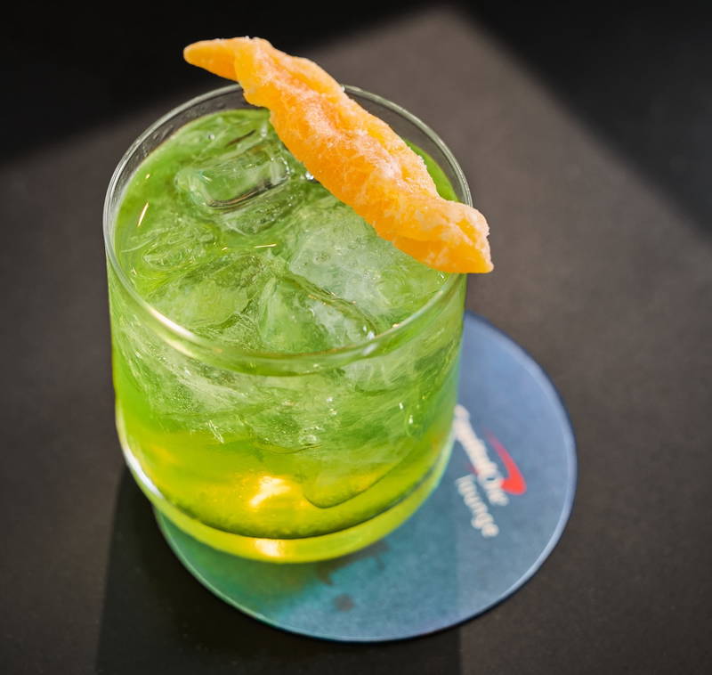 a glass with a drink and an orange slice on top
