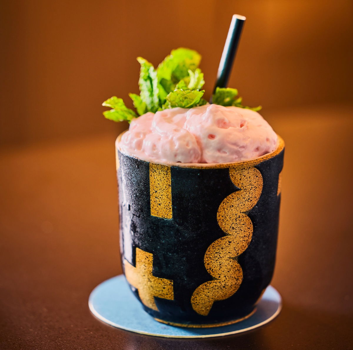 a cup of pink drink with mint leaves