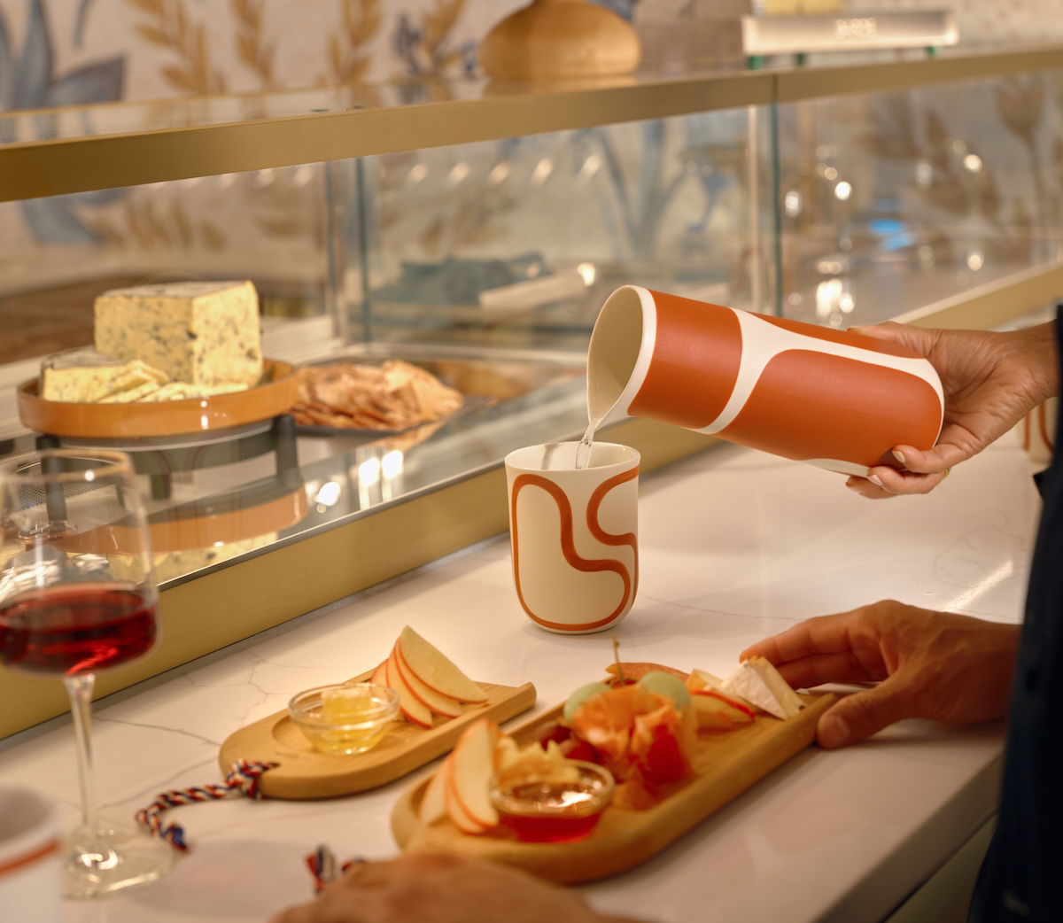 a person pouring a drink into a cup
