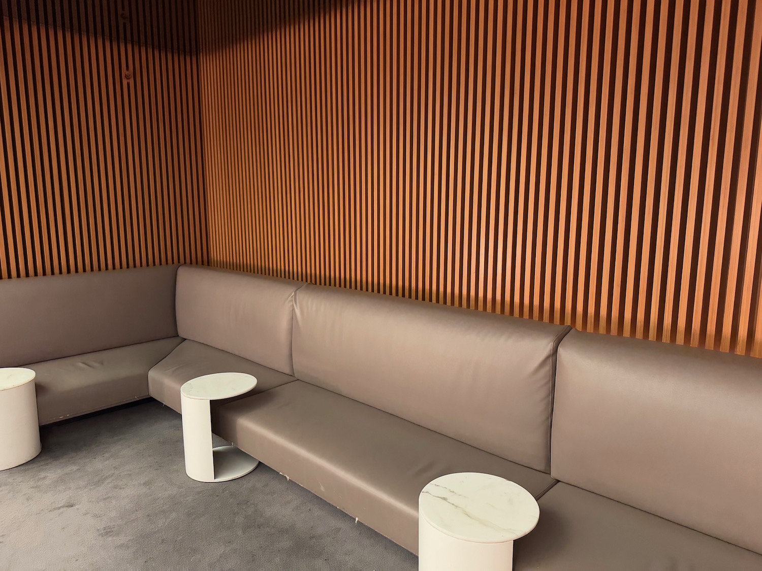 a couch with a table in front of a wood paneled wall