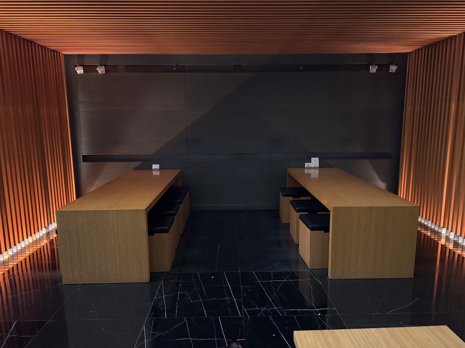 a room with wooden tables and black tile floor