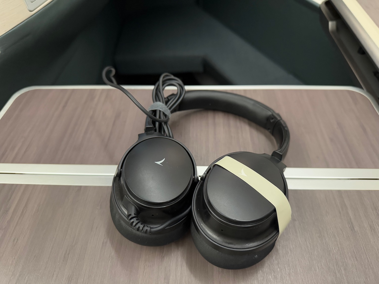 a pair of black headphones on a wood surface