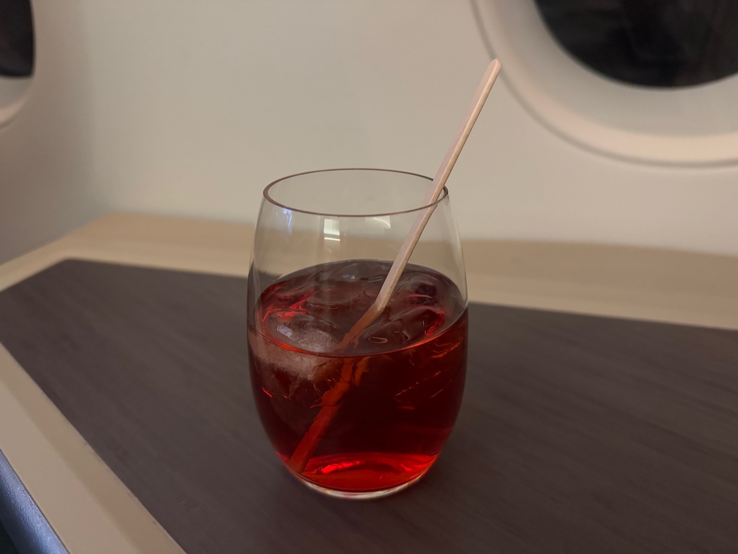 a glass with red liquid and ice and a straw