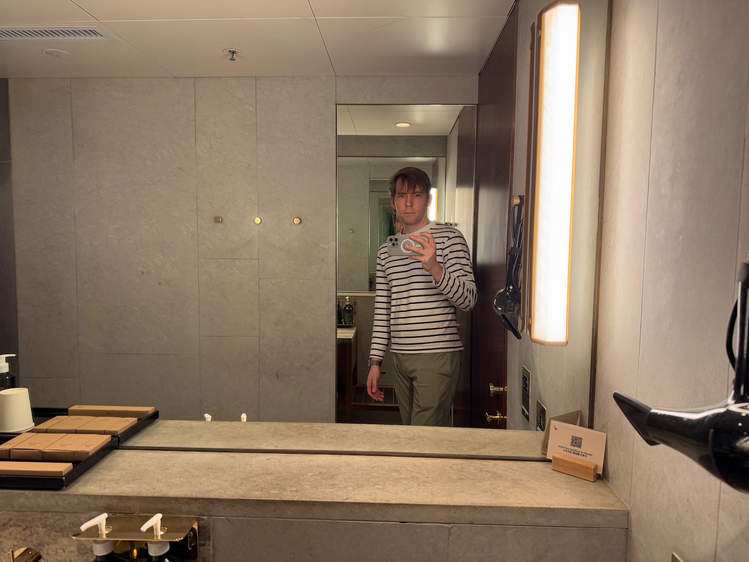 a man taking a selfie in a bathroom mirror