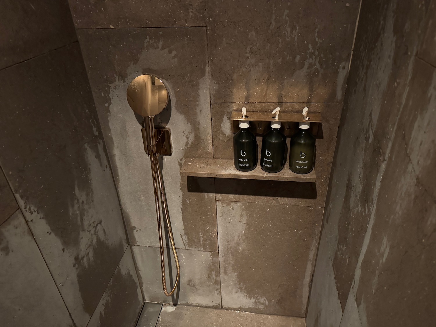 a shower with bottles and a mirror