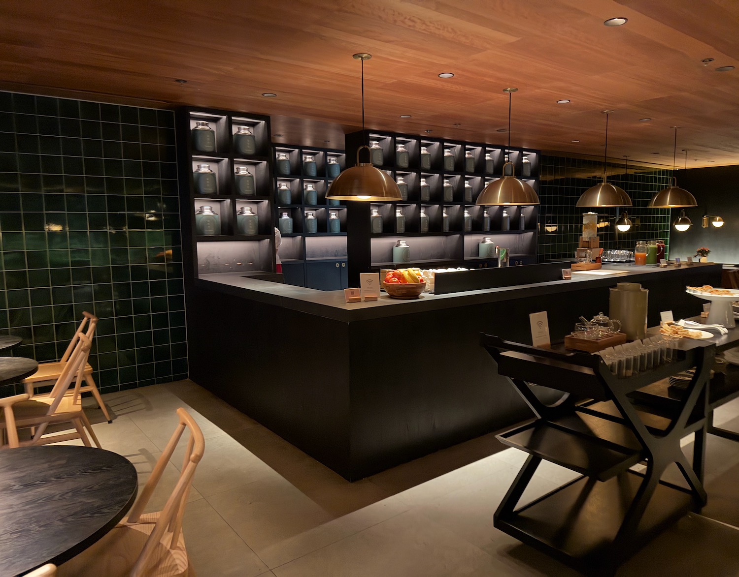 a bar with a black counter and chairs