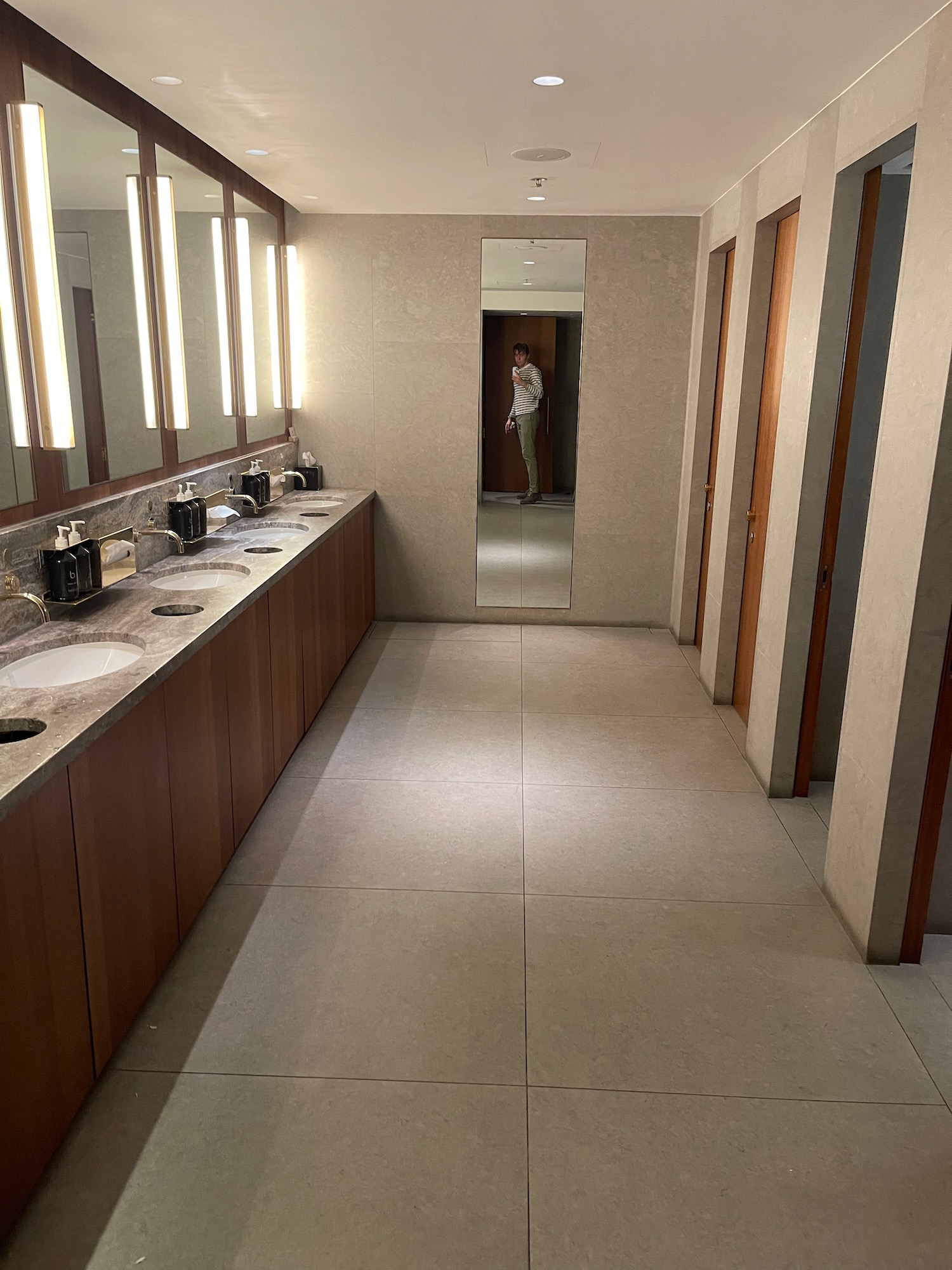 a bathroom with a man standing in the background