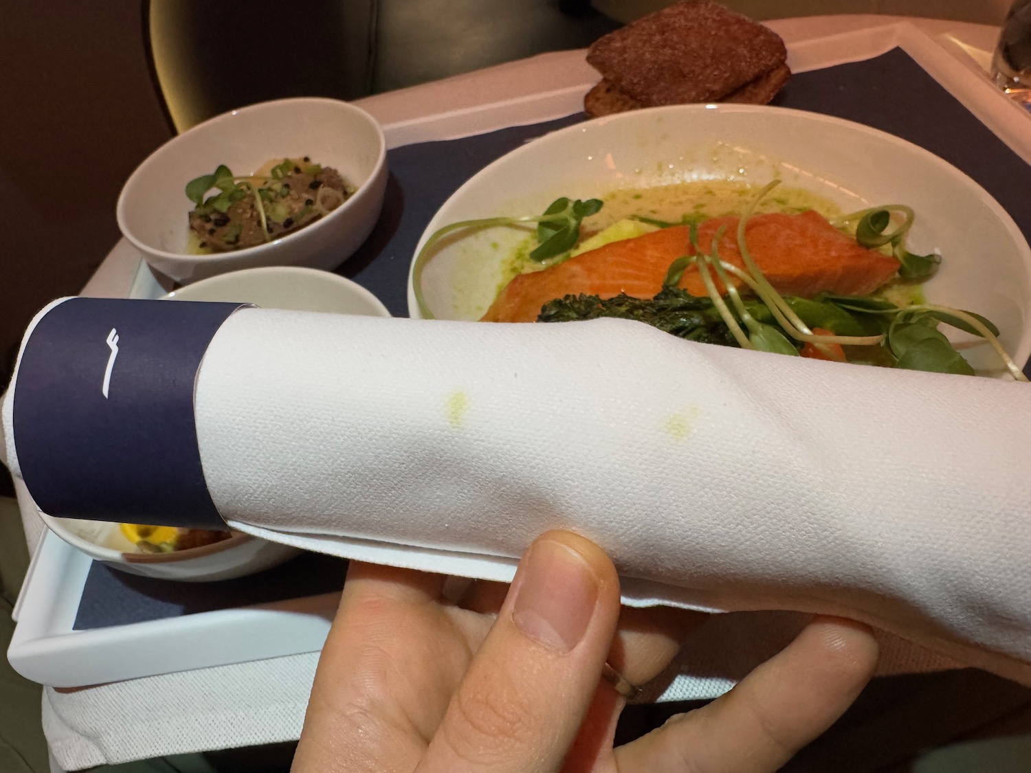 a hand holding a napkin over a bowl of food
