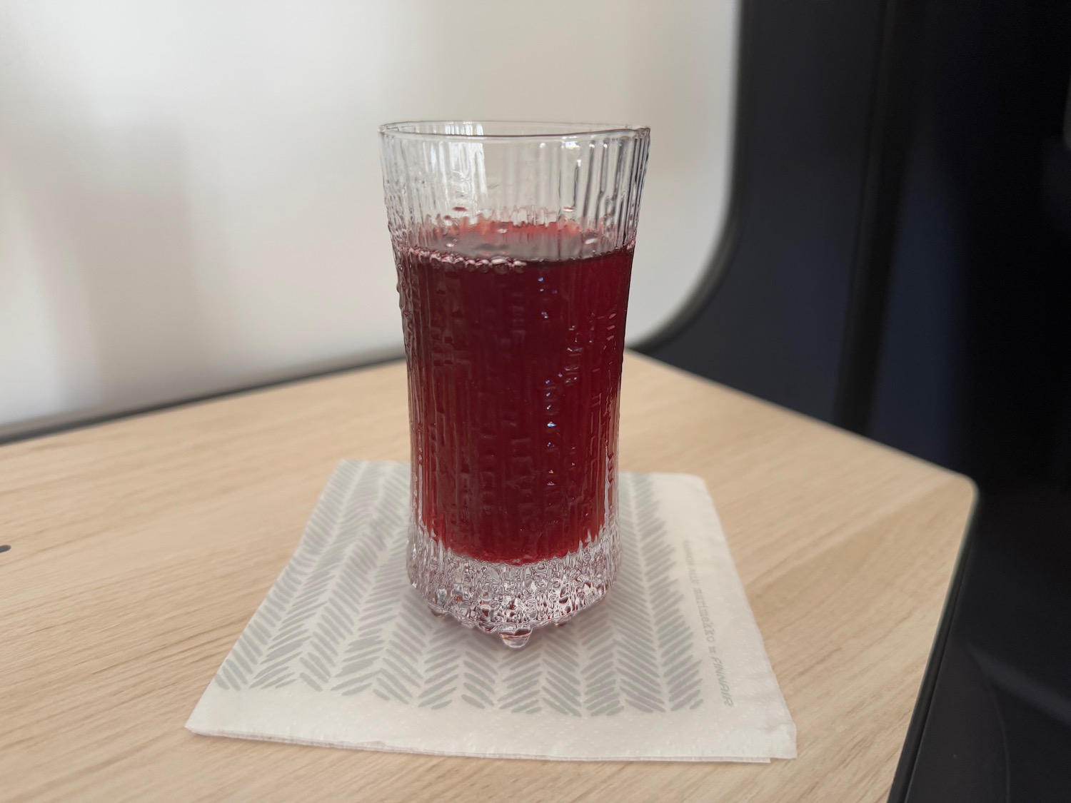 a glass of red liquid on a napkin