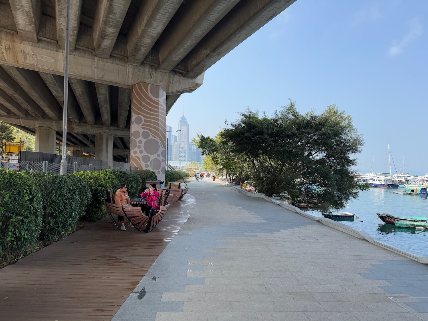a group of people sitting on benches under a bridge