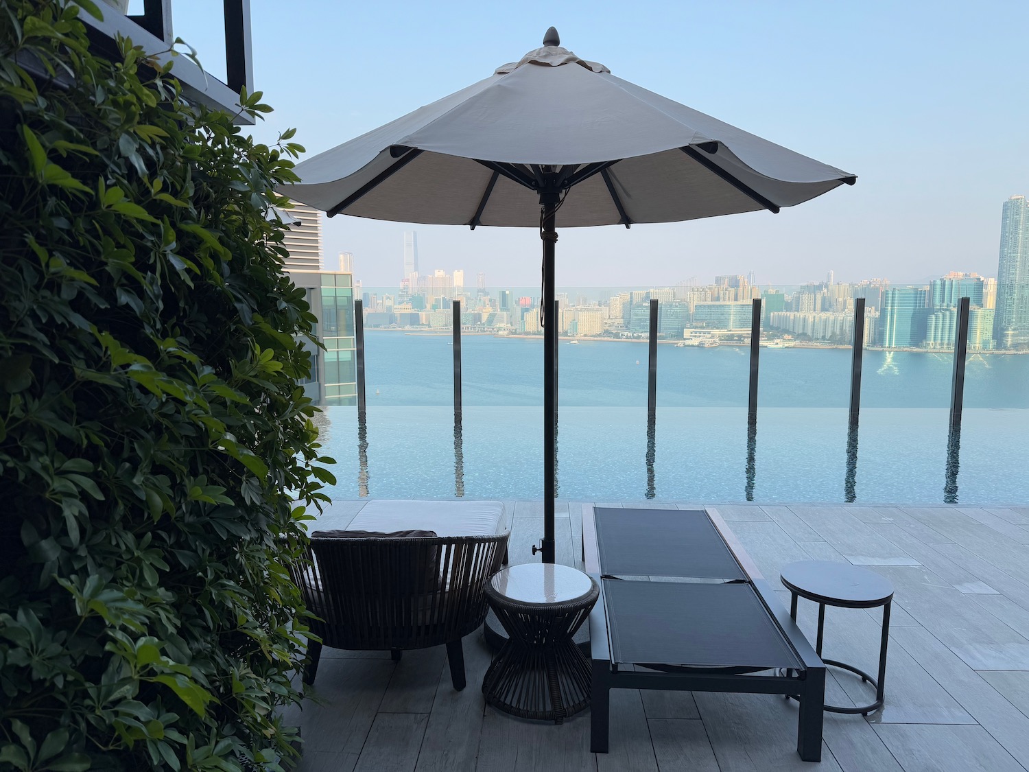 a pool with a large umbrella and chairs
