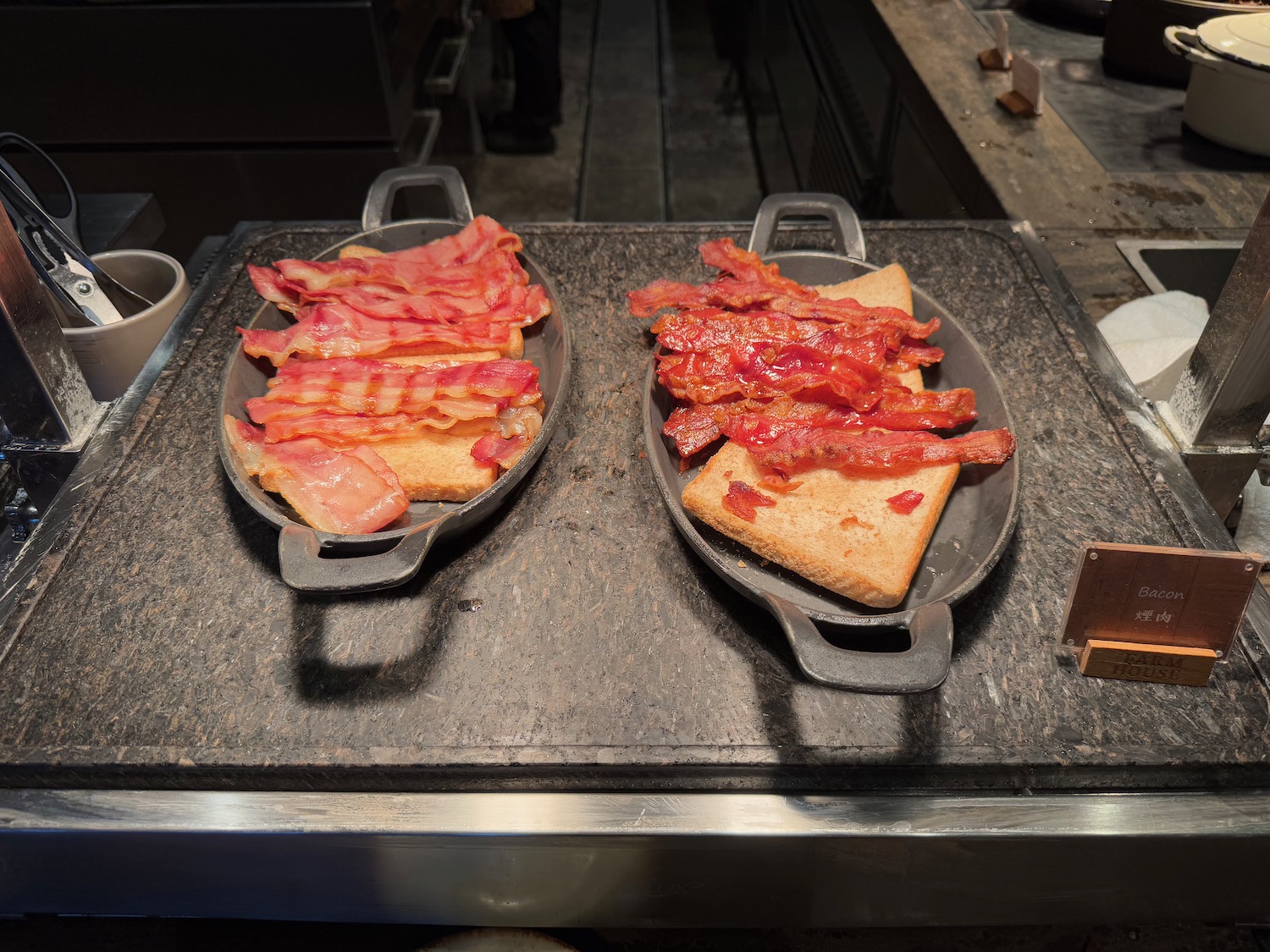 two plates of bacon and toast on a counter