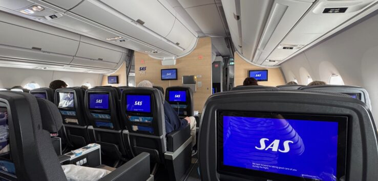 a row of seats with monitors on the back