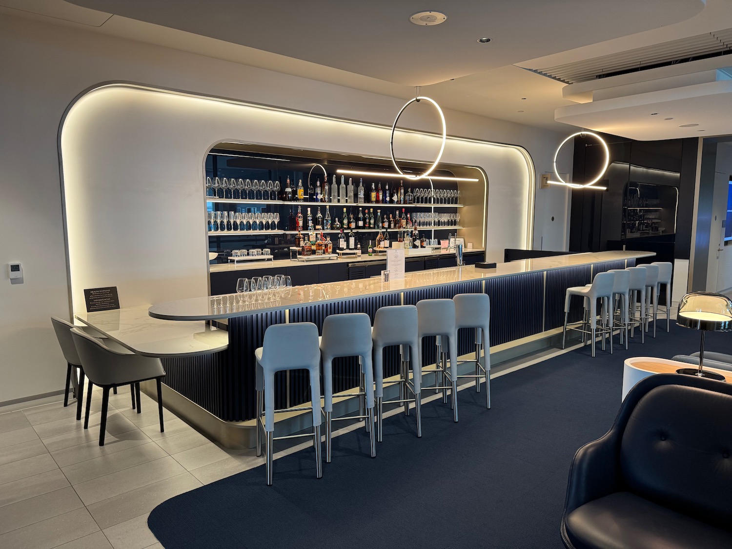 a bar with a row of chairs and a table with glasses