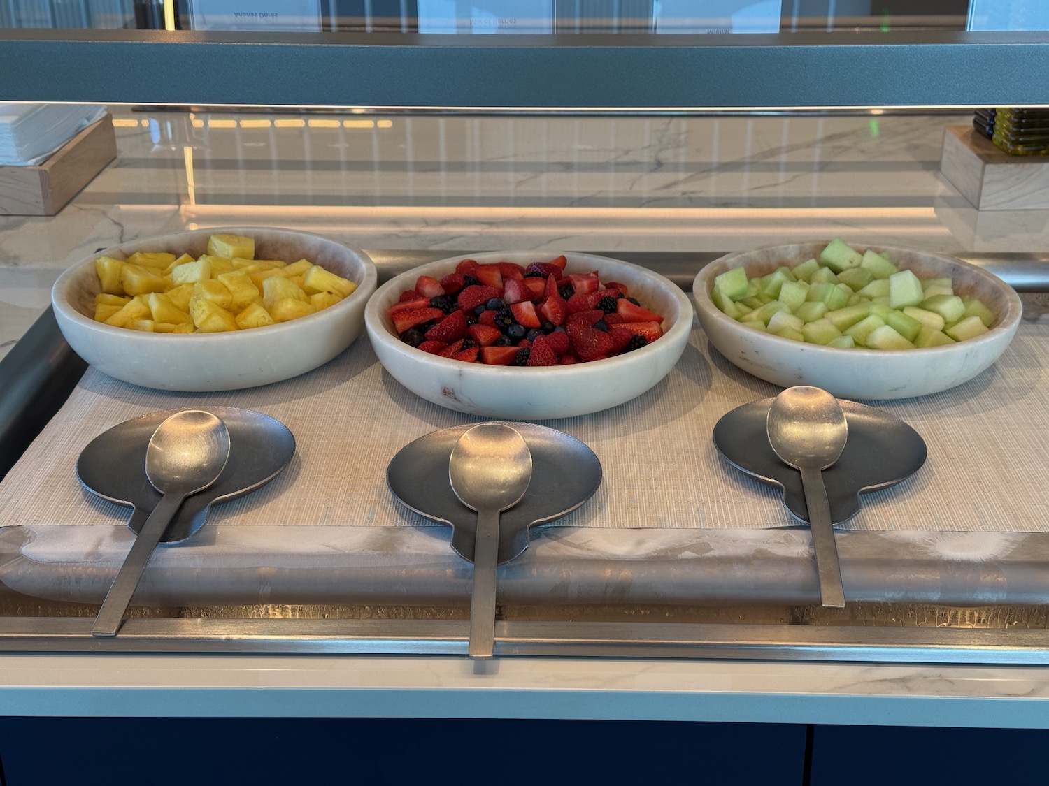 a group of bowls of fruit and spoons