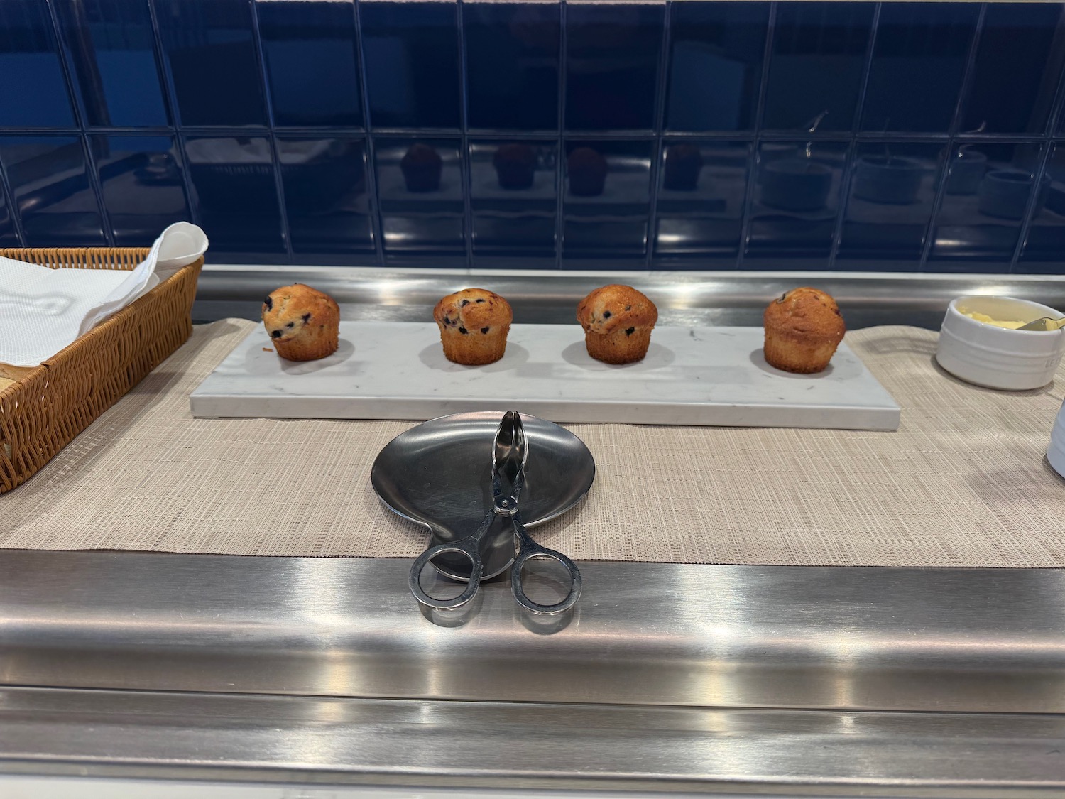 a tray with muffins and scissors on a table