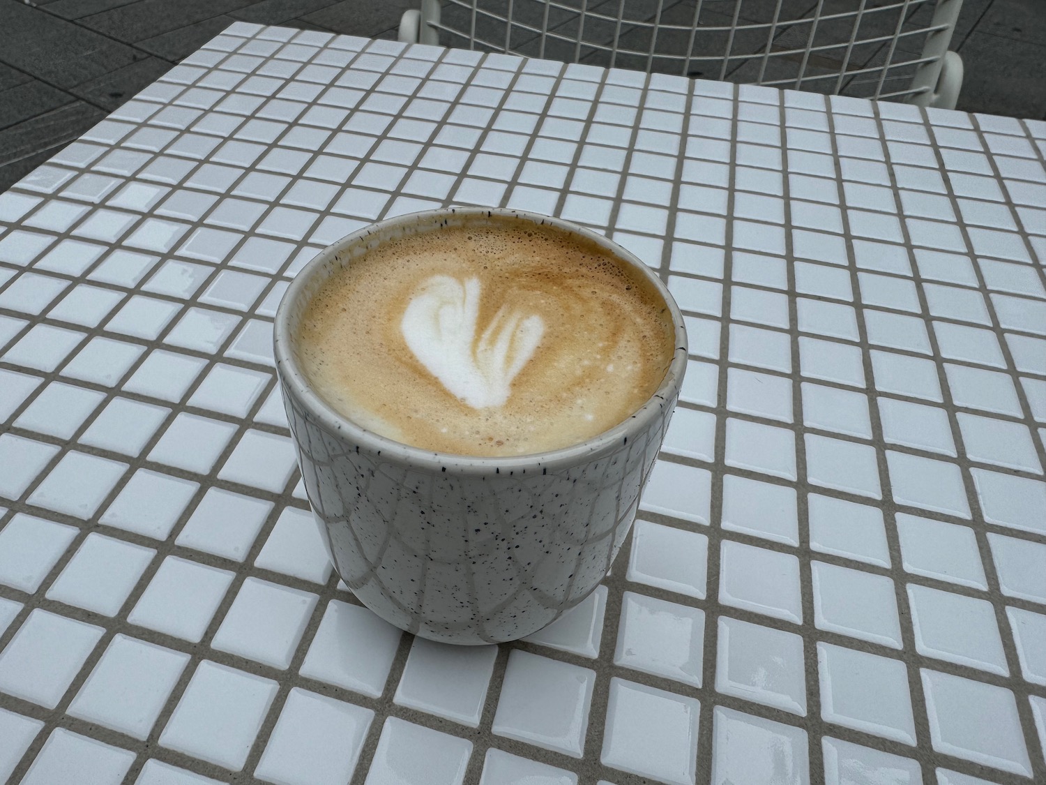 a cup of coffee on a tile table