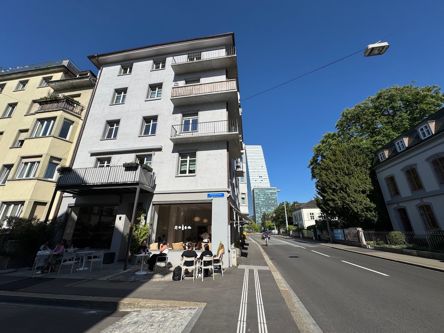 a street with a building and a street with trees and a street light