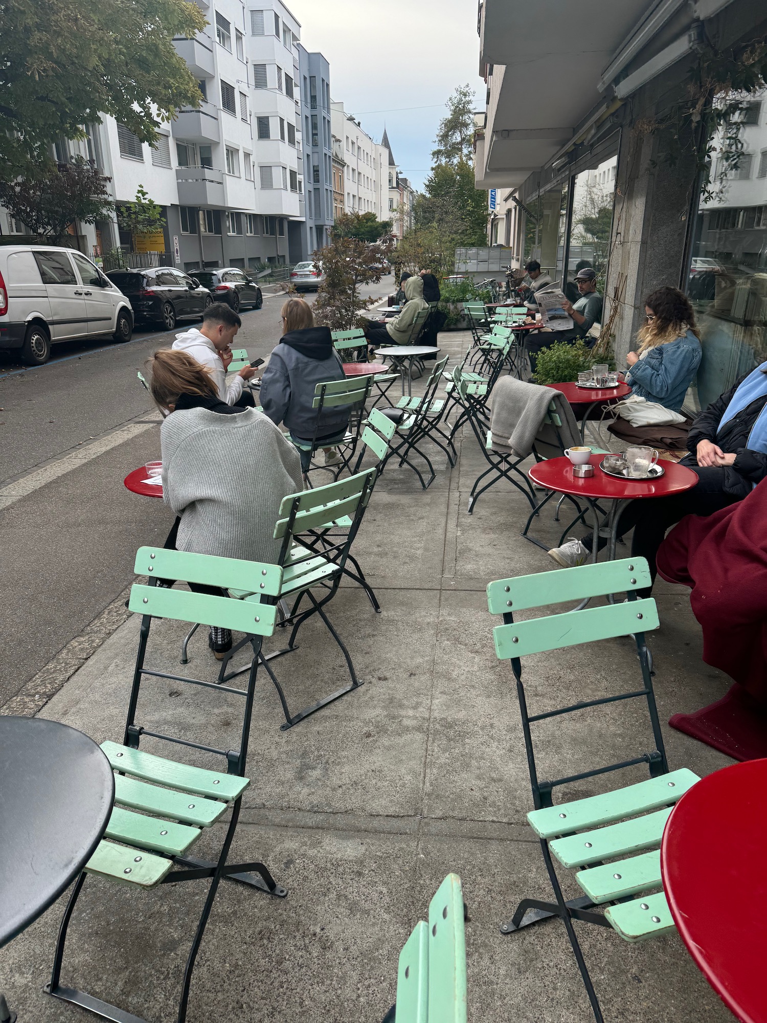 a group of people sitting at tables outside a building