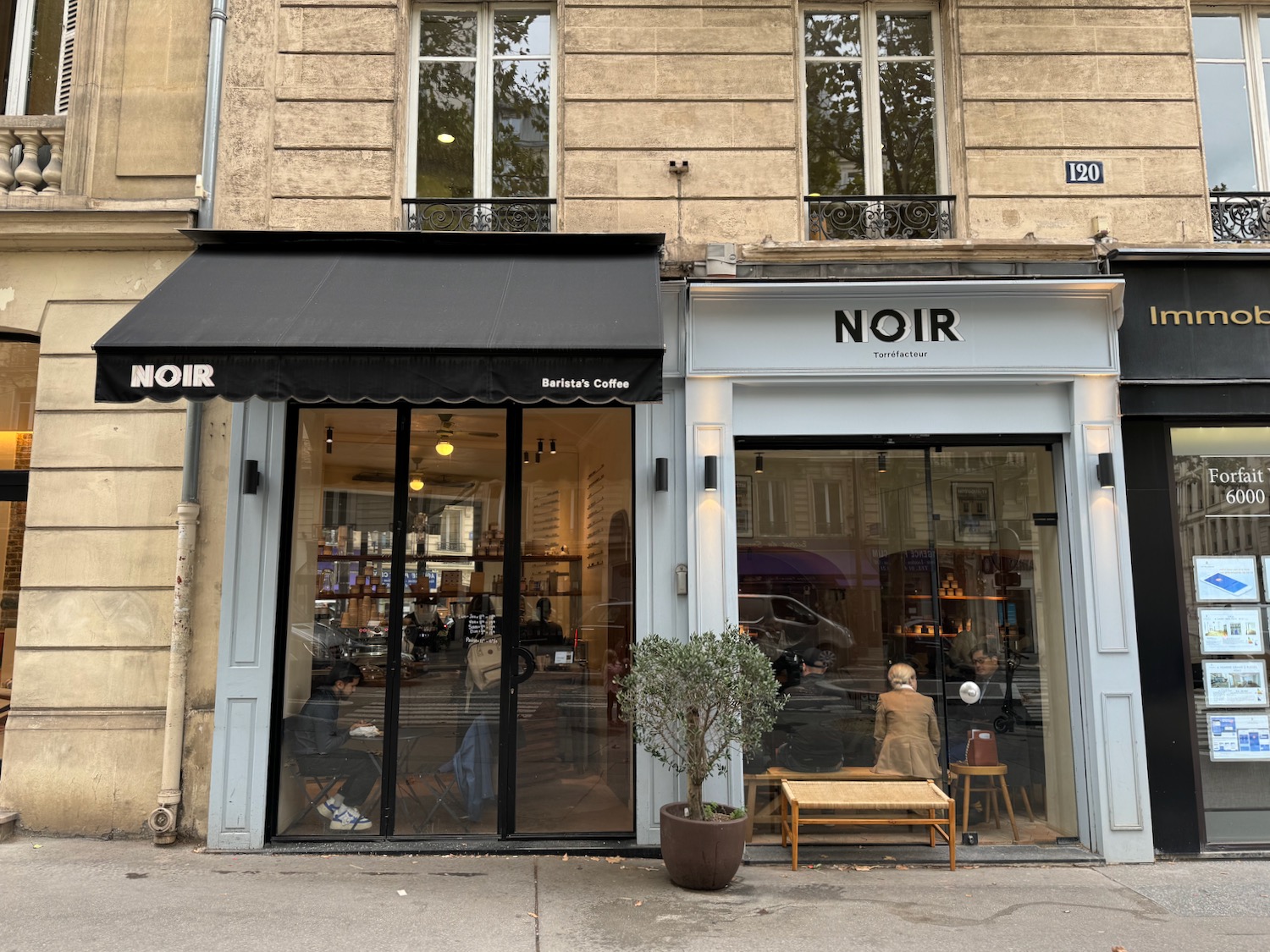 a store front with a person sitting in the window