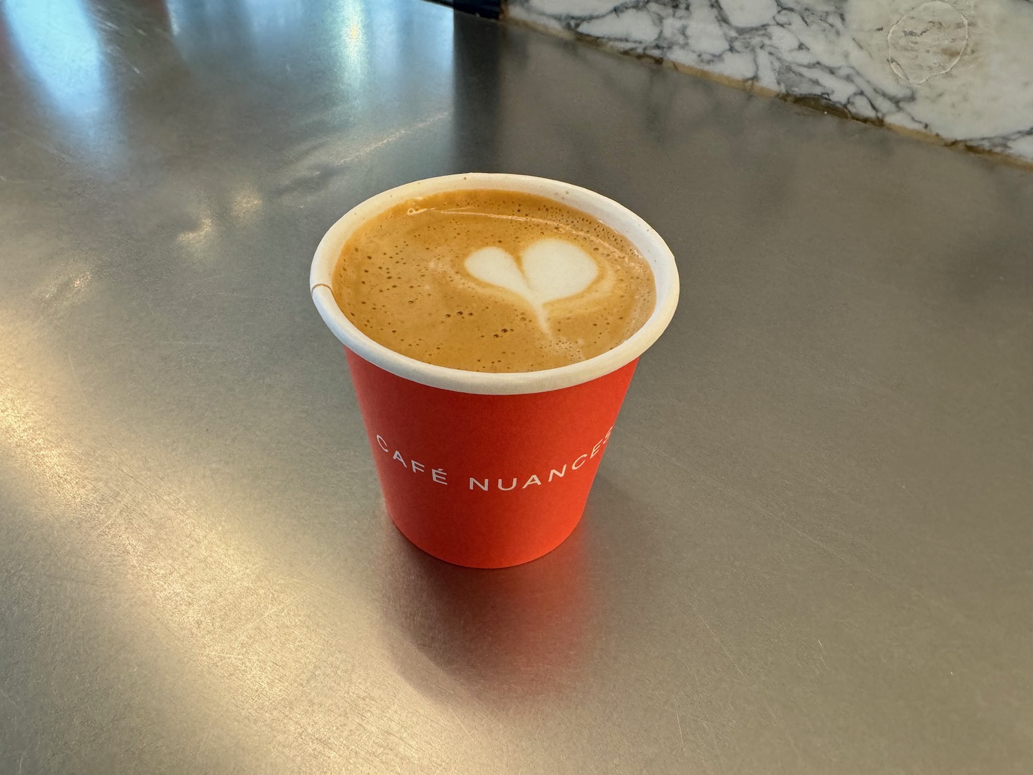 a cup of coffee with a heart in the foam
