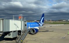 a blue and white airplane on a tarmac