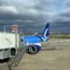 a blue and white airplane on a tarmac