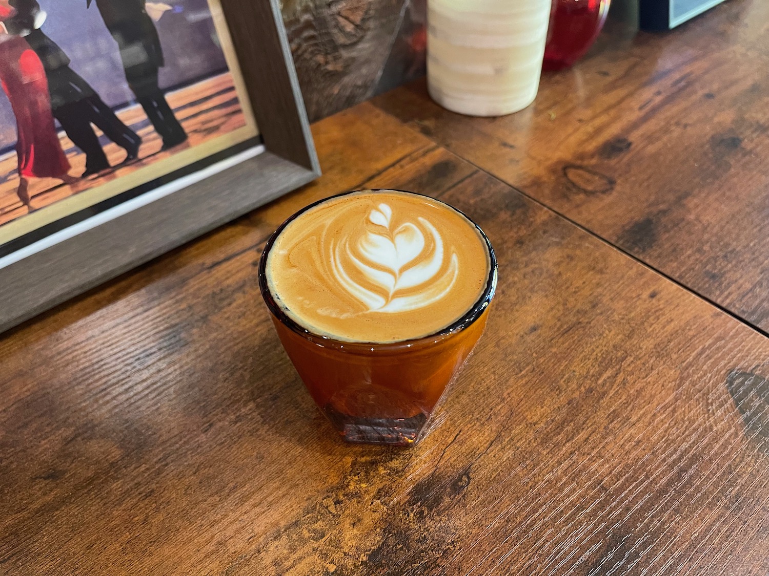a glass of coffee with a foamy foam in it