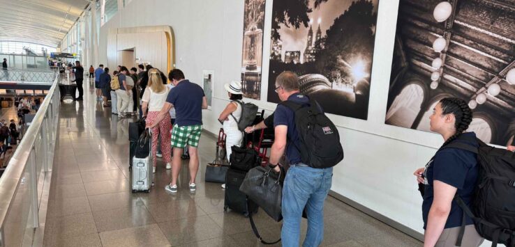 a group of people standing in a line with luggage